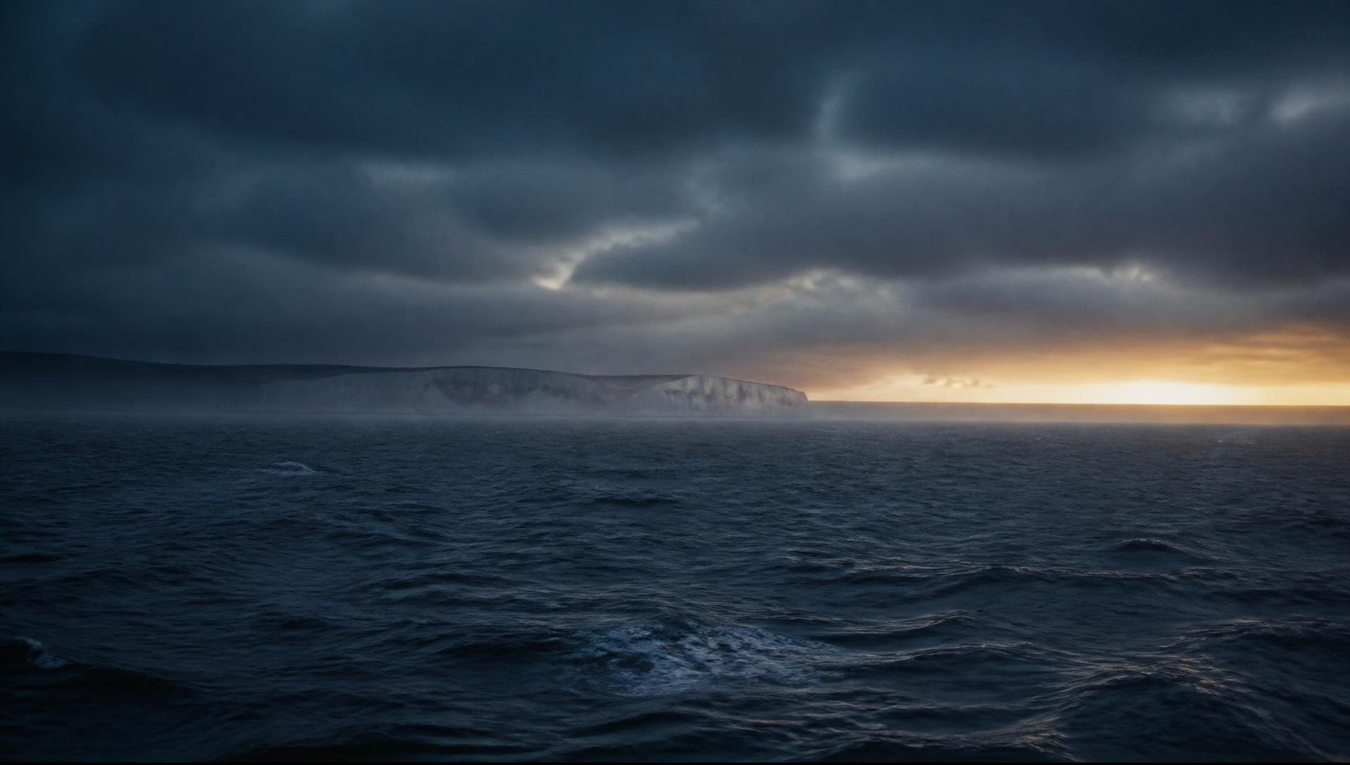 The open water of the English Channel at dawn with distant chalk cliffs